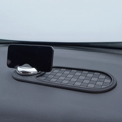 Car dashboard with a black phone holder and mat